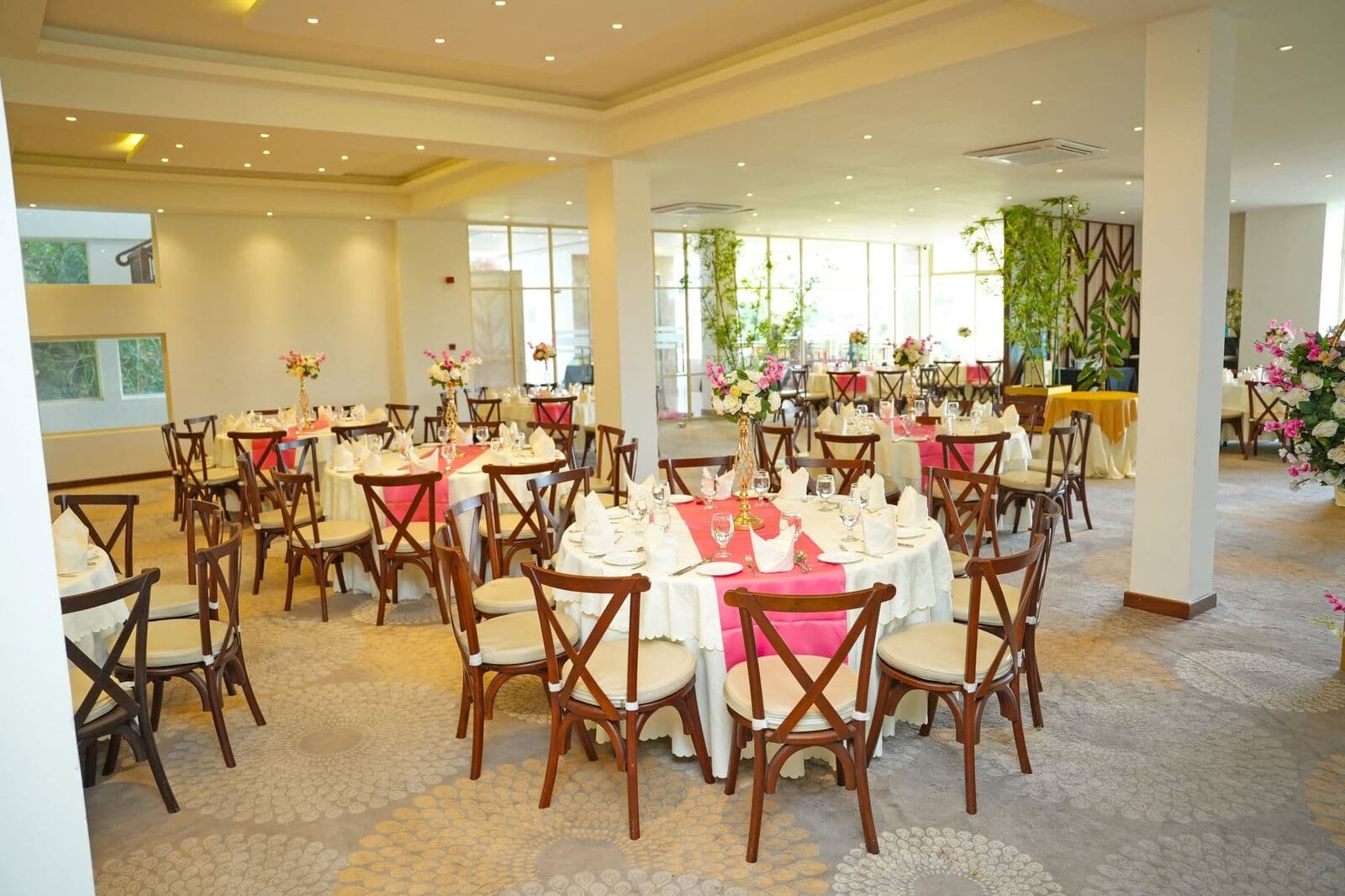 Ambrosia with round tables laid in pink and white, and big windows
