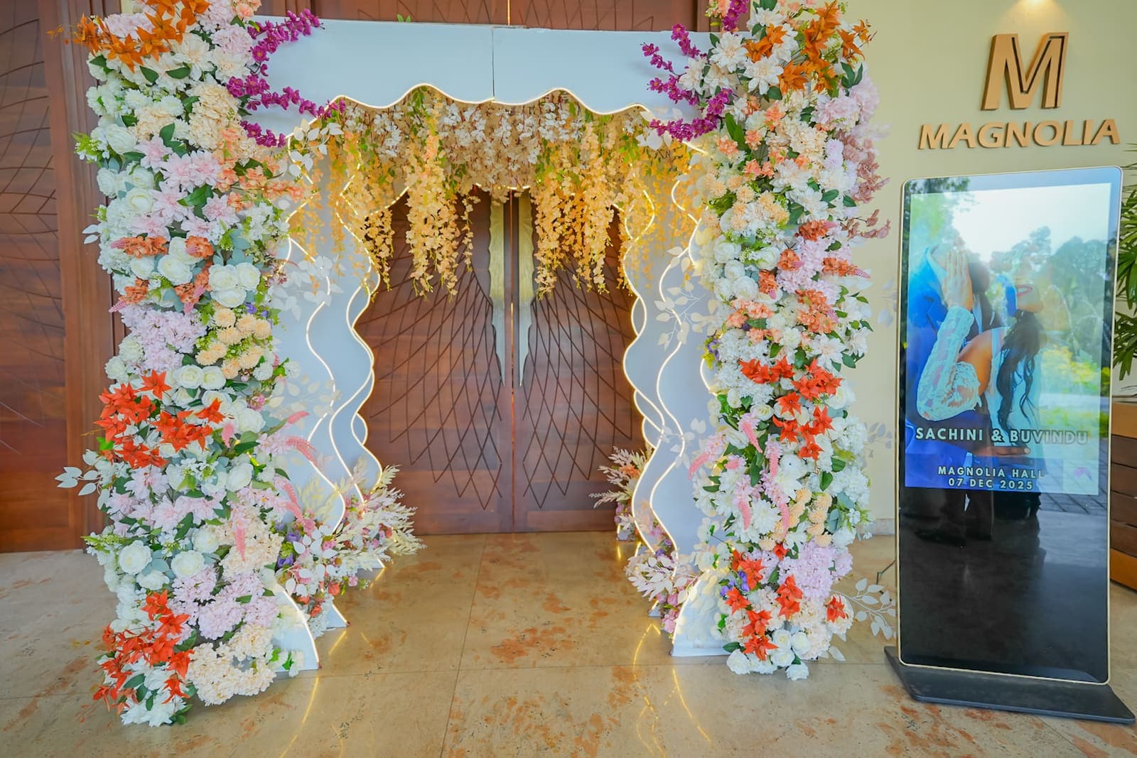 The Magnolia hall's entrance arch covered in orange and white flowers