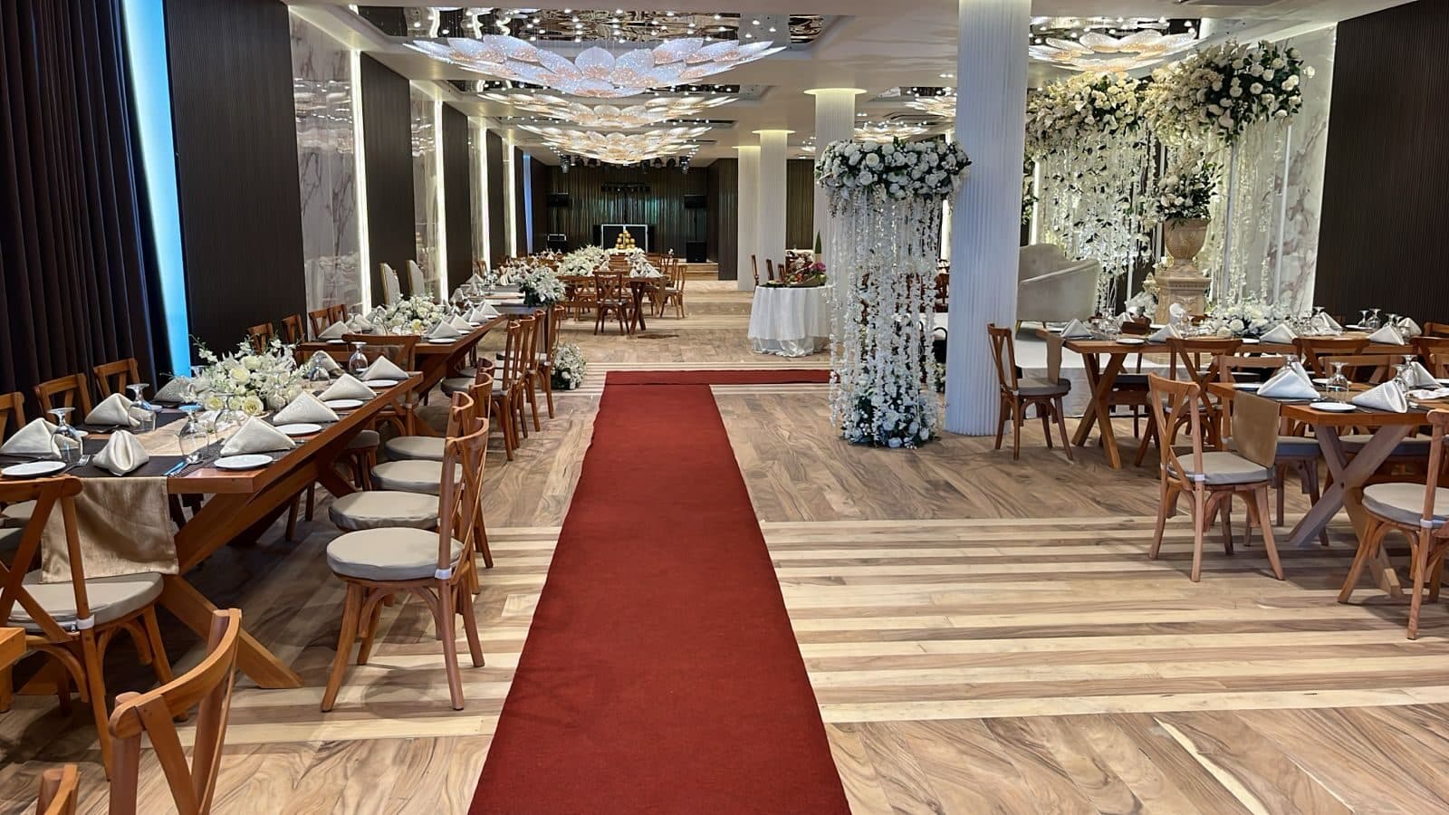 Wisteria laid for a wedding: a red carpet across the wooden floor, long wooden tables and a crystal ceiling
