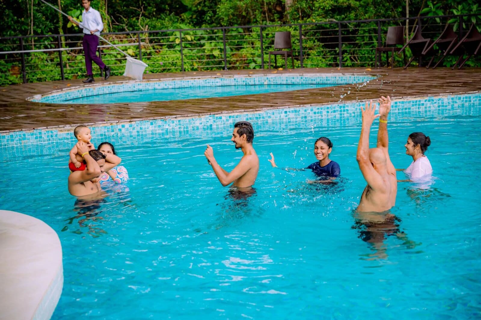 A family splashing and laughing together in the pool