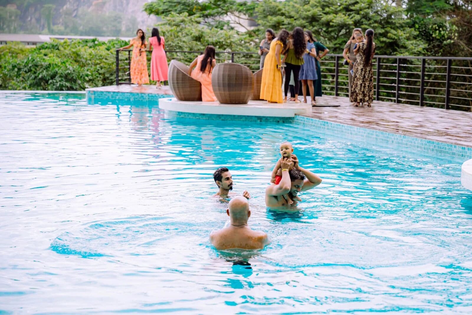 Guests swimming and chatting at the edge of the infinity pool