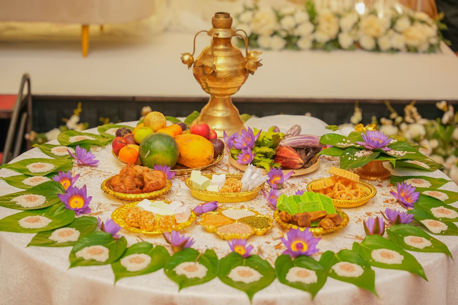 A traditional tray of fruit and sweets on a ring of banana leaves