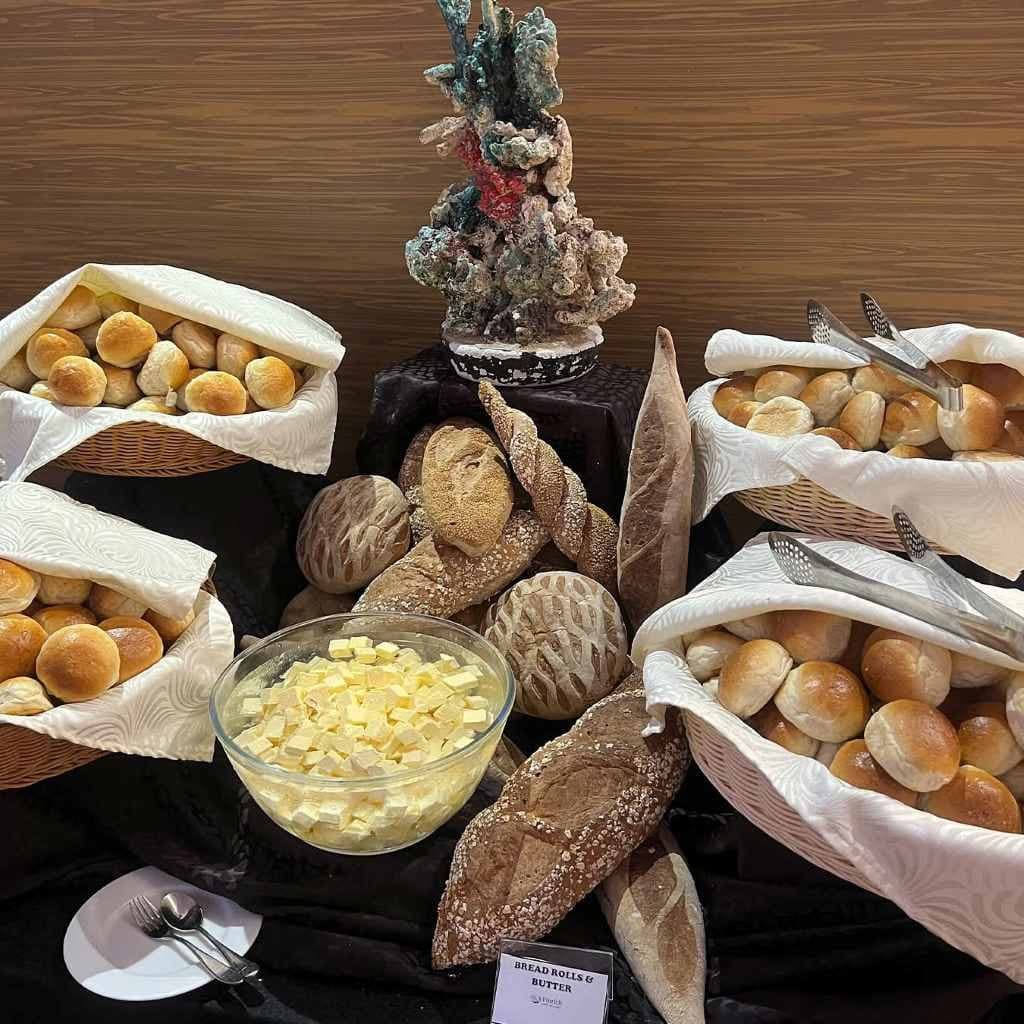 A table of fresh breads and rolls in linen-lined baskets