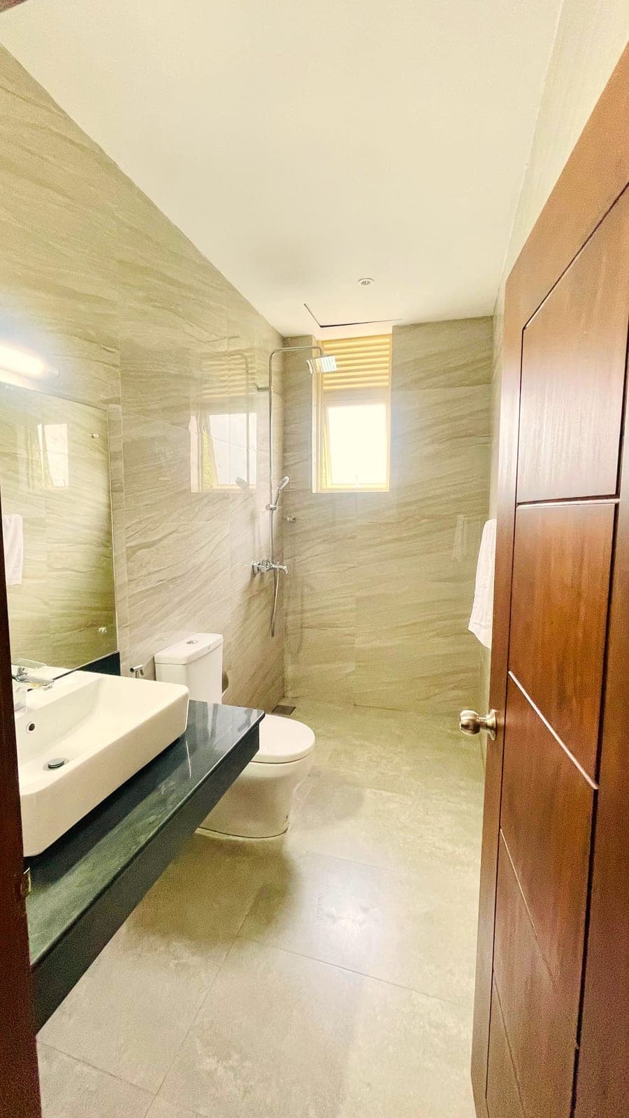 A bathroom with a long vanity and a glass-walled shower