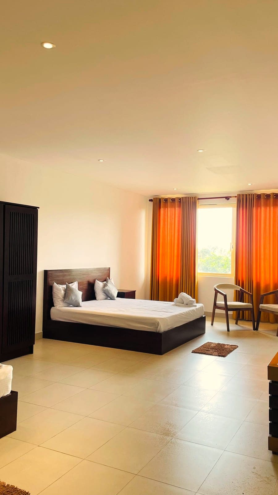 A bright room with orange curtains and a window seat
