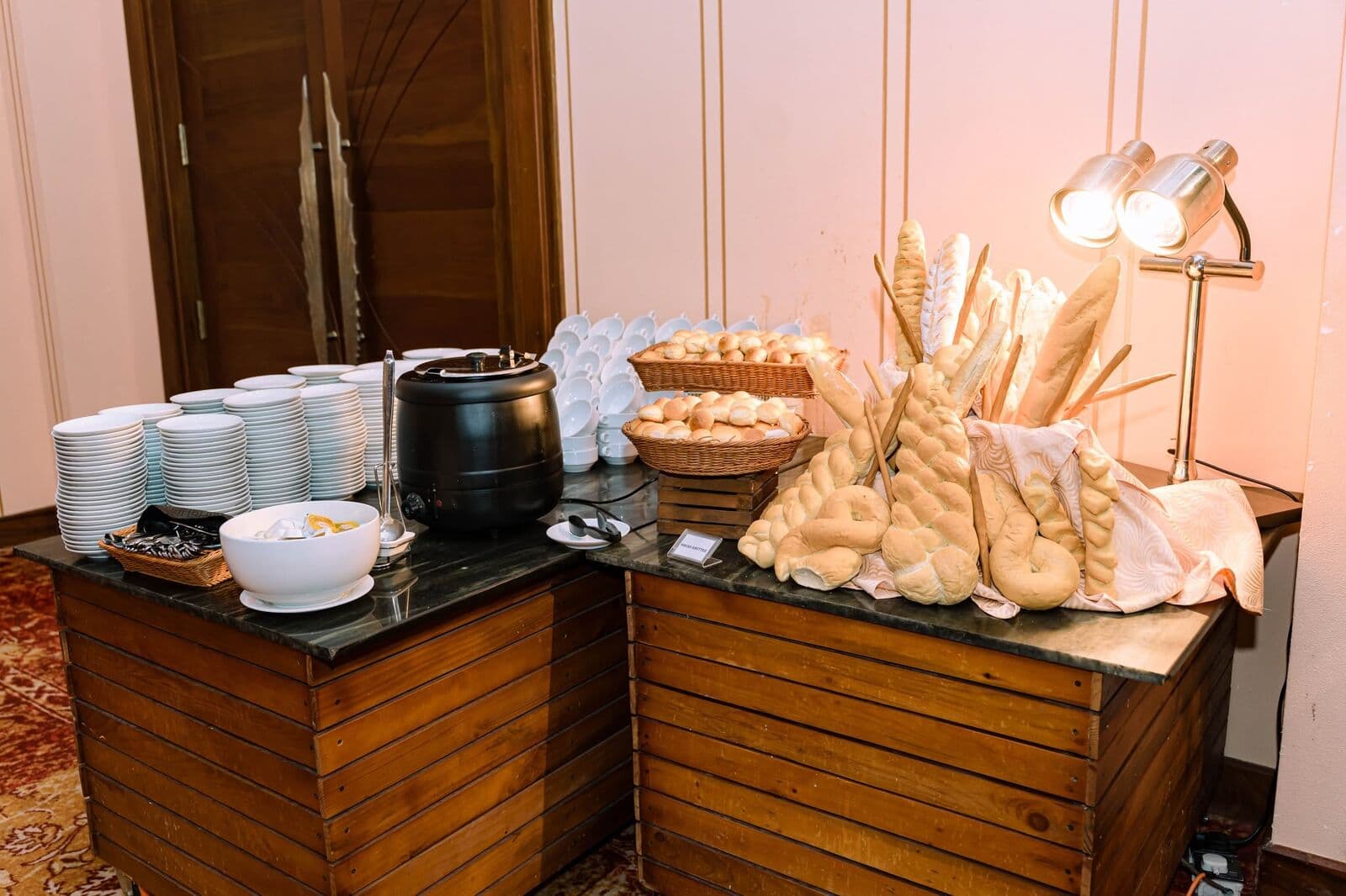 A bread station with baskets of rolls, baguettes and a soup tureen