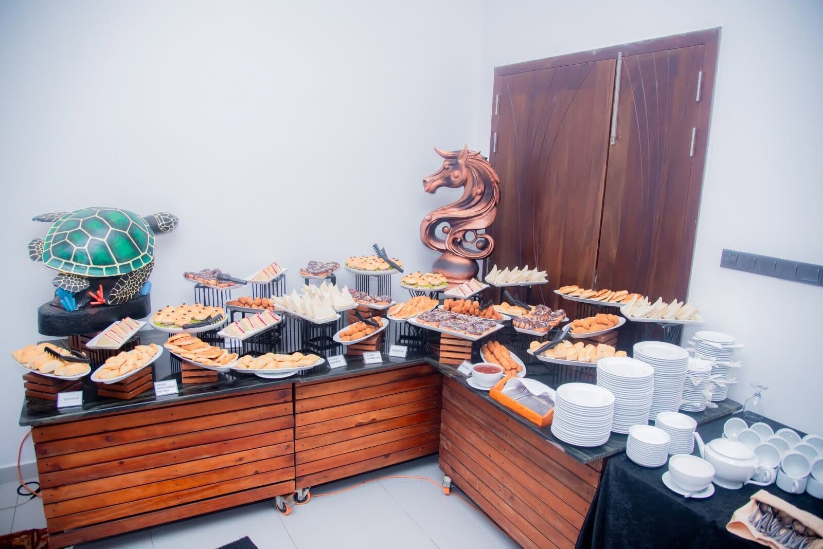 A long buffet counter of short eats and desserts