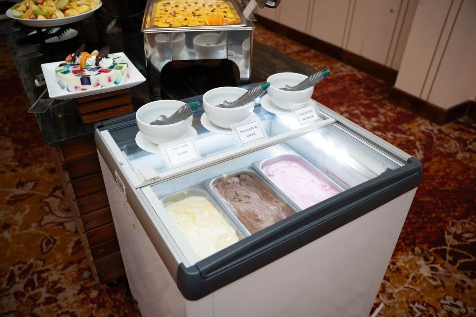 Three tubs of ice cream in a freezer counter at the buffet