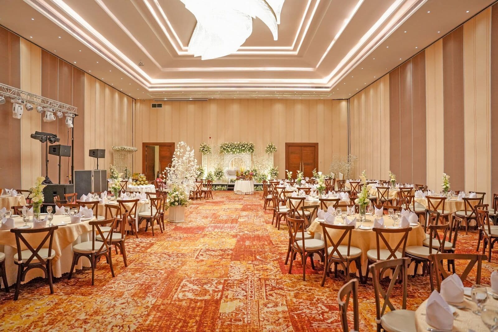 A long hall with rows of round tables leading to the stage