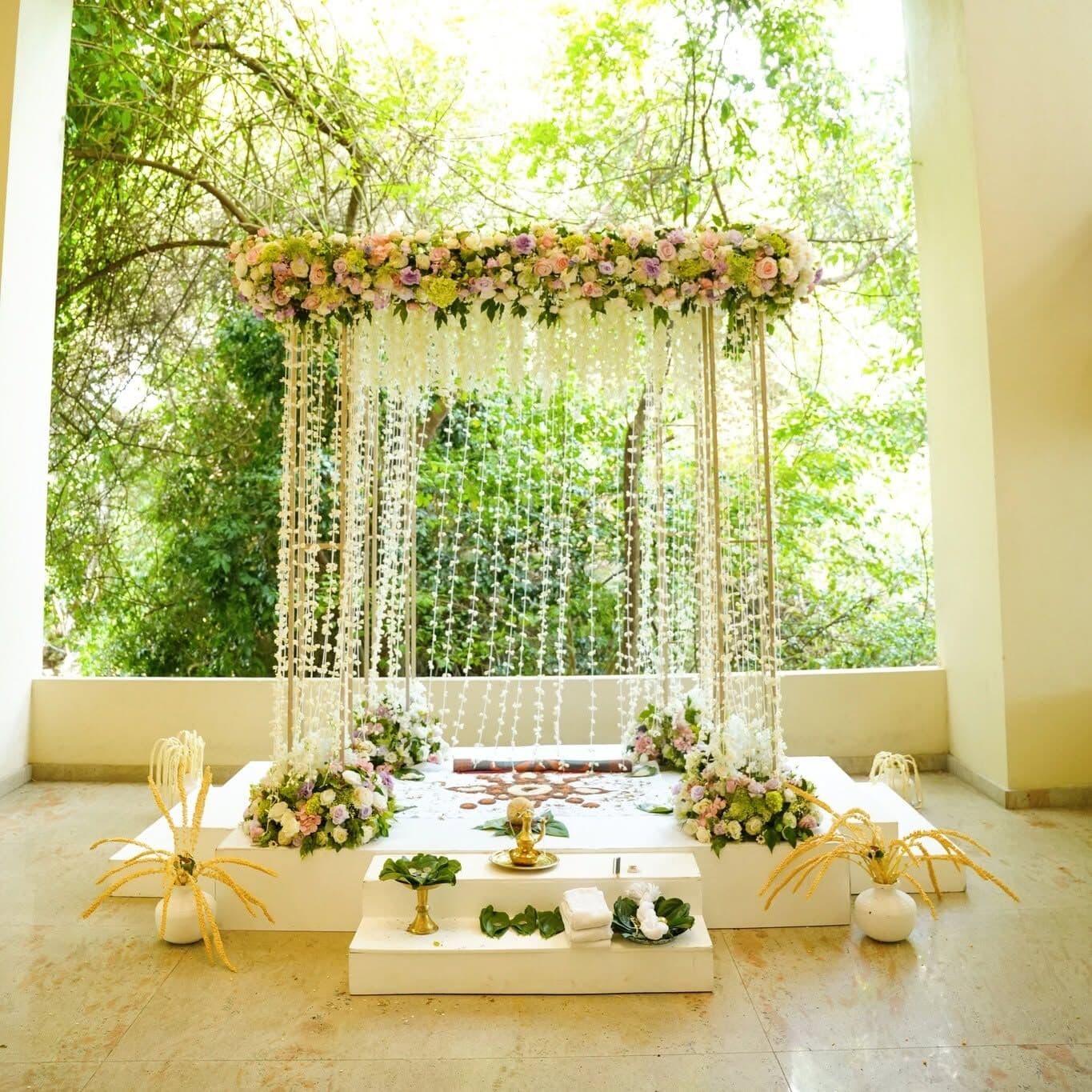 A flower-decked poruwa on the terrace, with trees behind