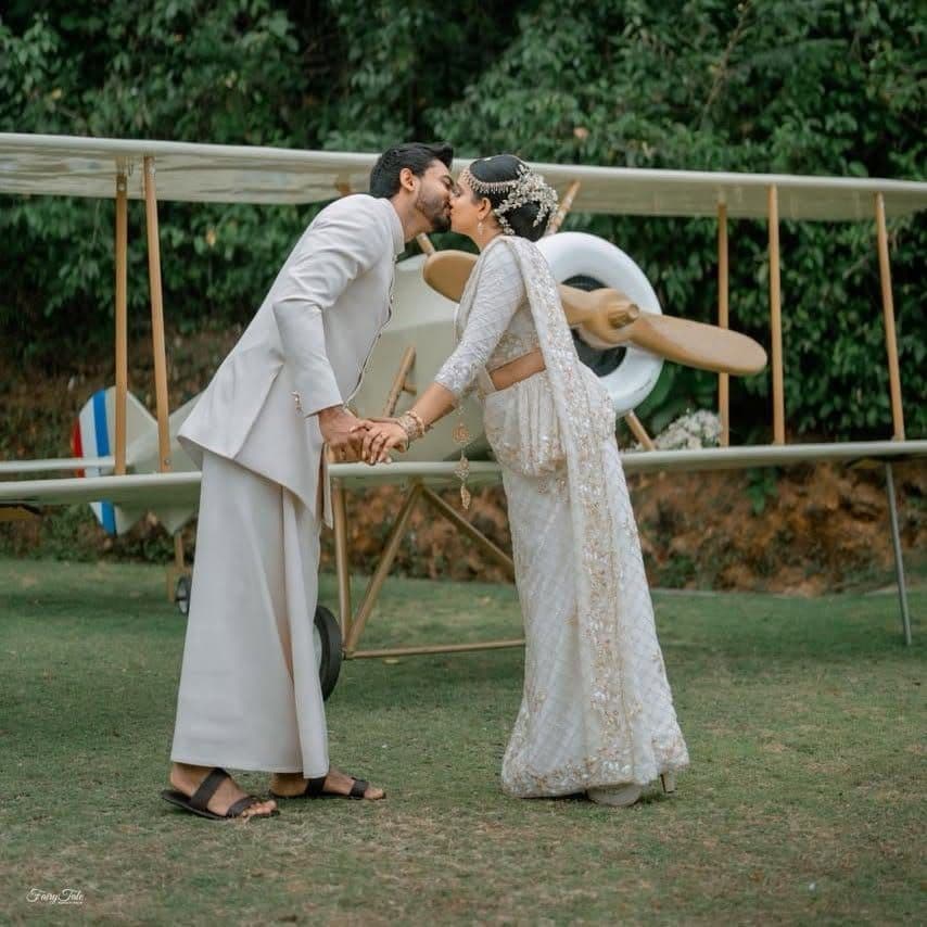 A couple kissing in front of the vintage aeroplane on the lawn