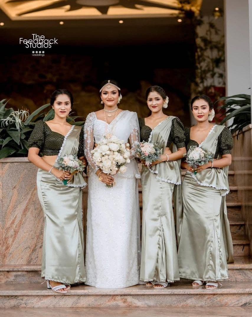 A bride with three bridesmaids in sage green on the lobby stairs