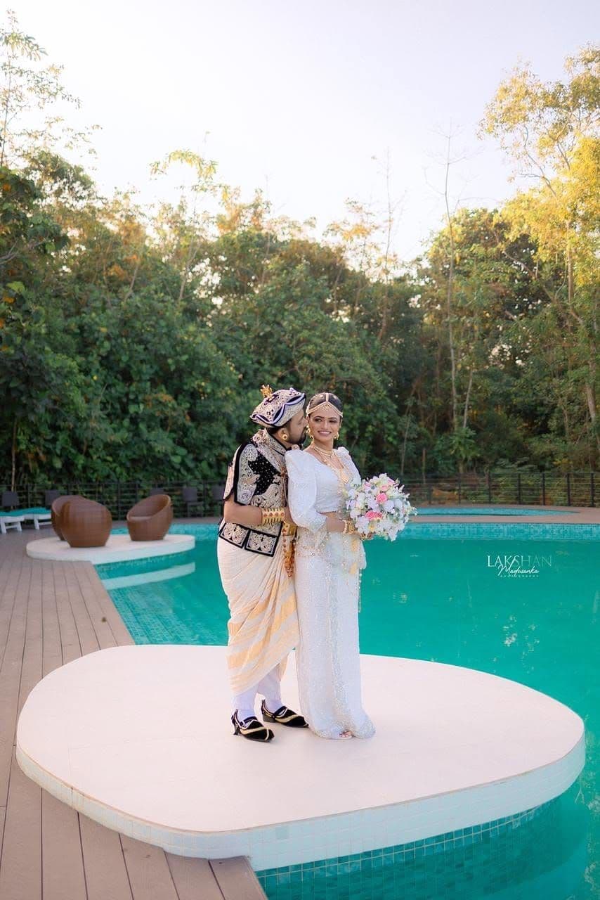 A bride and groom on a round platform in the pool