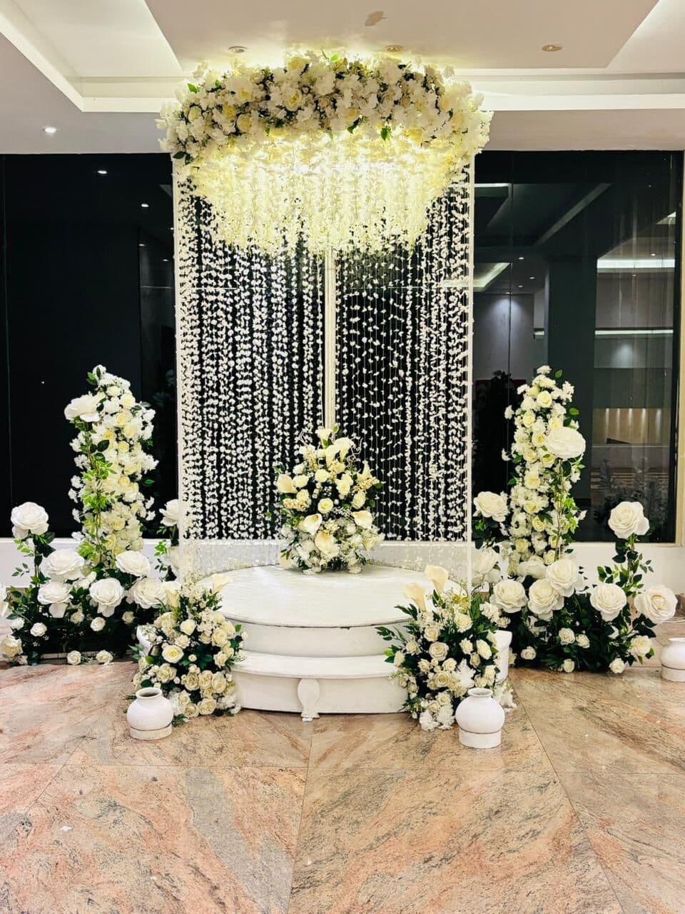 A round white platform with flowers and hanging strings in Wisteria