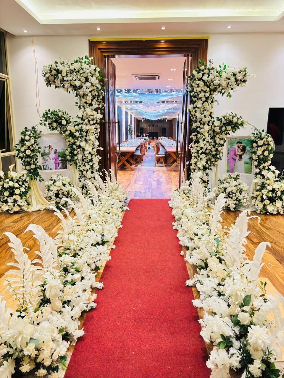 A red carpet between white flowers, leading into Wisteria