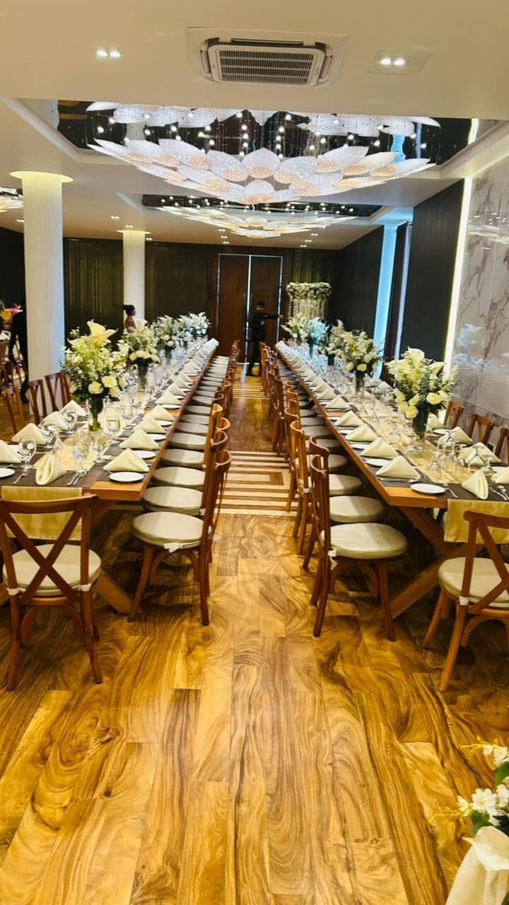 Wisteria laid with long wooden tables, white flowers and wooden chairs